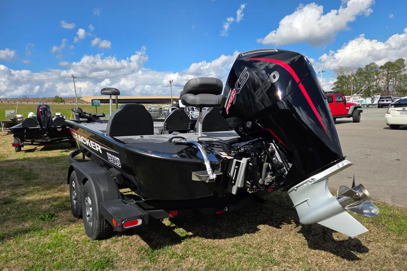 Slide: The Image of 2025 Tracker Savage 215 boat with powerful outboard motor, parked outdoors under blue sky. - 4