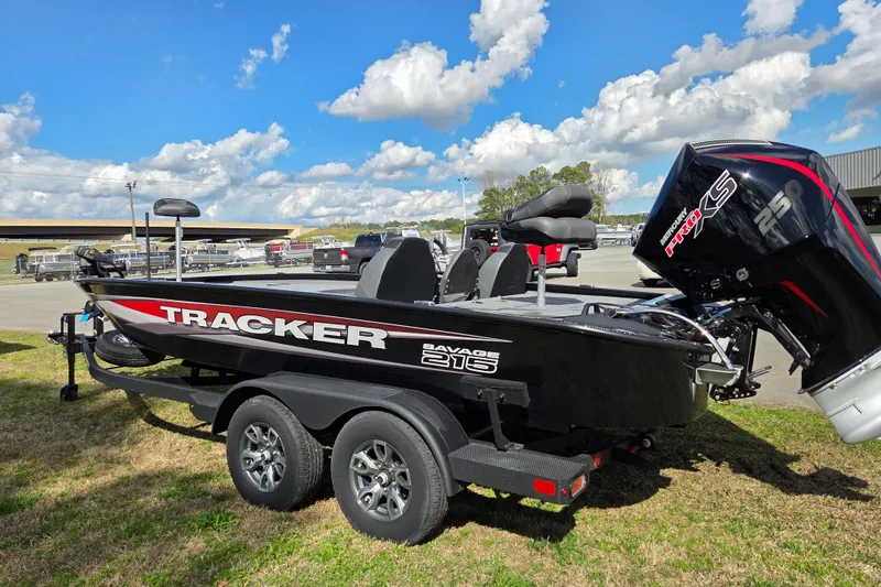 Slide: The Image of 2025 Tracker Savage 215 boat on trailer, featuring powerful Mercury engine, under blue sky. - 5