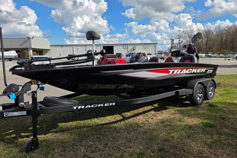 Slide: The Image of 2025 Tracker Savage 215 boat on trailer, parked outdoors under a cloudy sky. - 6