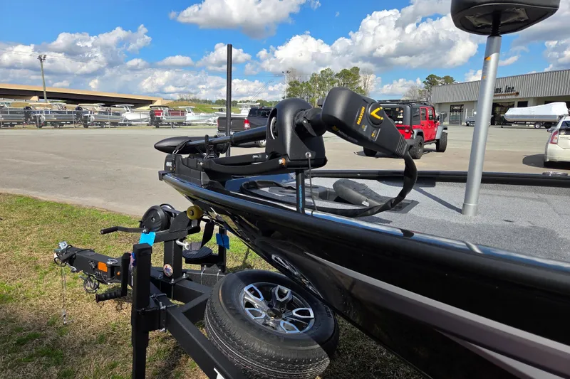 Slide: The Image of 2025 Tracker Savage 215 boat on trailer, parked outdoors under a cloudy sky. - 7
