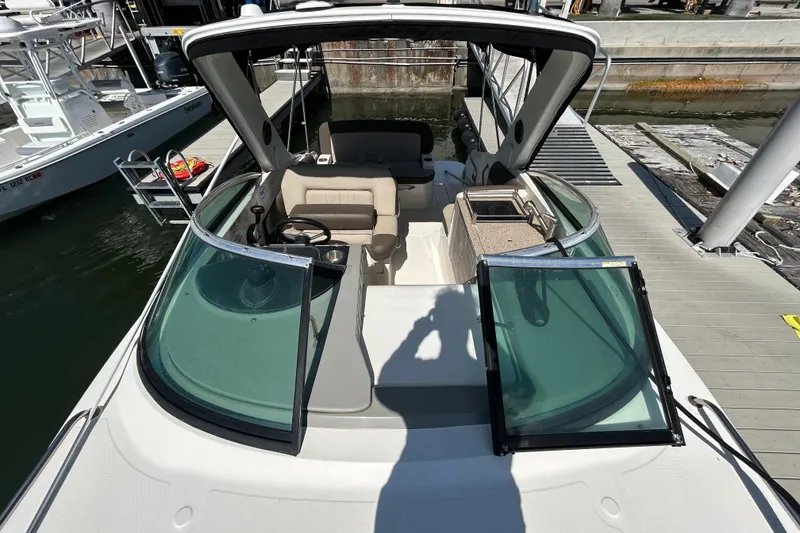 Slide: The Image of 2014 Sea Ray Sundancer 260 boat interior with helm, seating, and dashboard controls. - 28