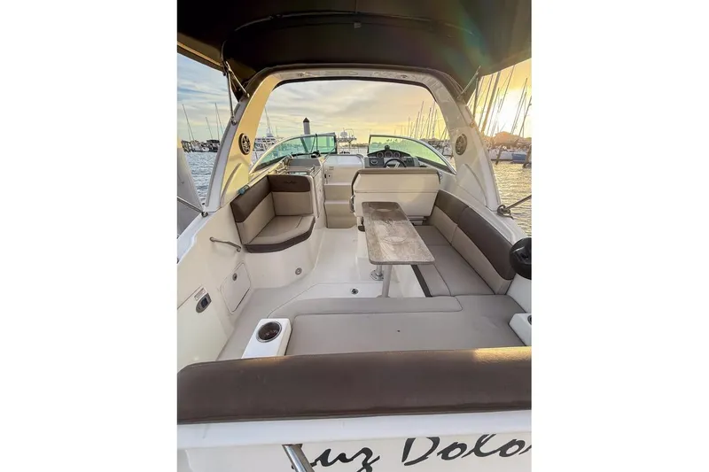 Slide: The Image of 2014 Sea Ray Sundancer 260 interior with seating and table, docked at sunset. - 3