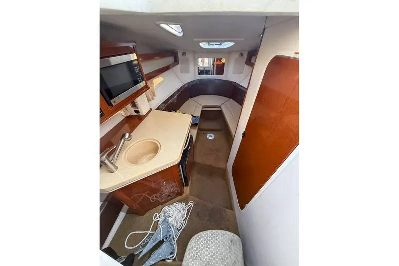 Slide: The Image of 2014 Sea Ray Sundancer 260 cabin interior with kitchenette and seating area. - 5