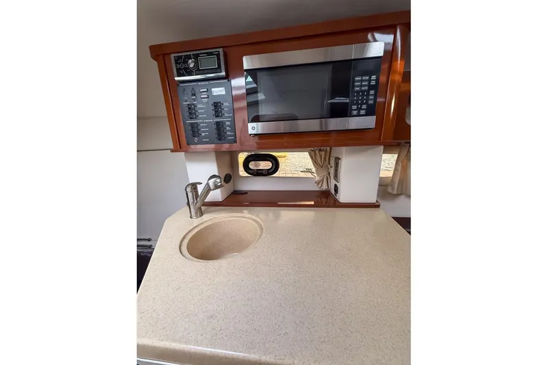 Slide: The Image of 2014 Sea Ray Sundancer 260 galley with microwave, sink, and control panel. - 6