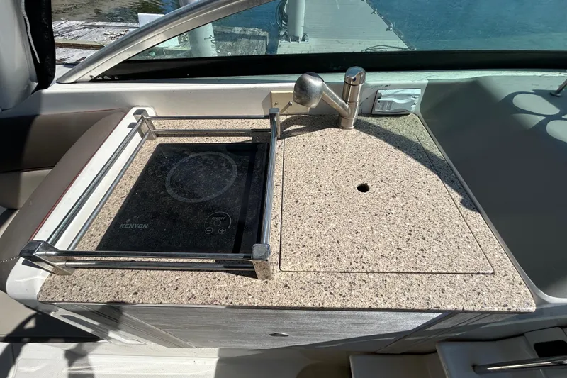 Slide: The Image of Interior view of 2014 Sea Ray Sundancer 260 boat with kitchenette and control panel. - 65