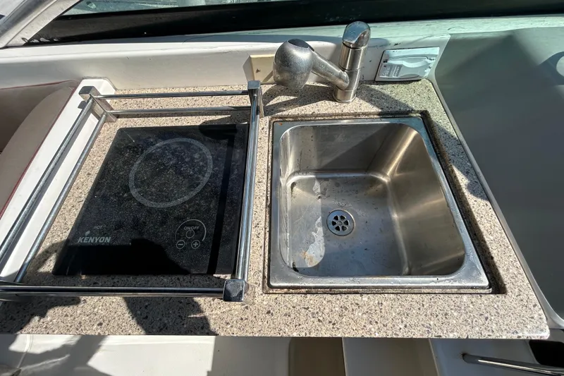 Slide: The Image of Compact bathroom in 2014 Sea Ray Sundancer 260 boat, featuring a toilet and storage shelf. - 66