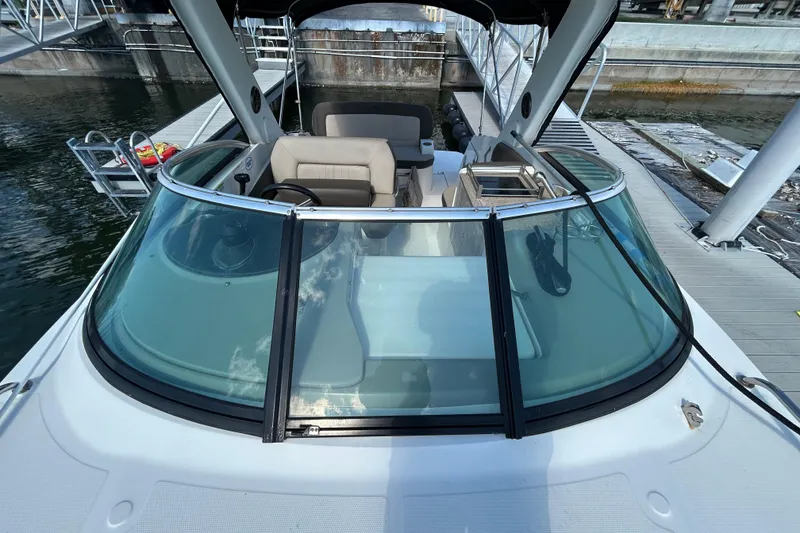 Slide: The Image of 2014 Sea Ray Sundancer 260 interior with sunset view, showcasing seating and canopy. - 74