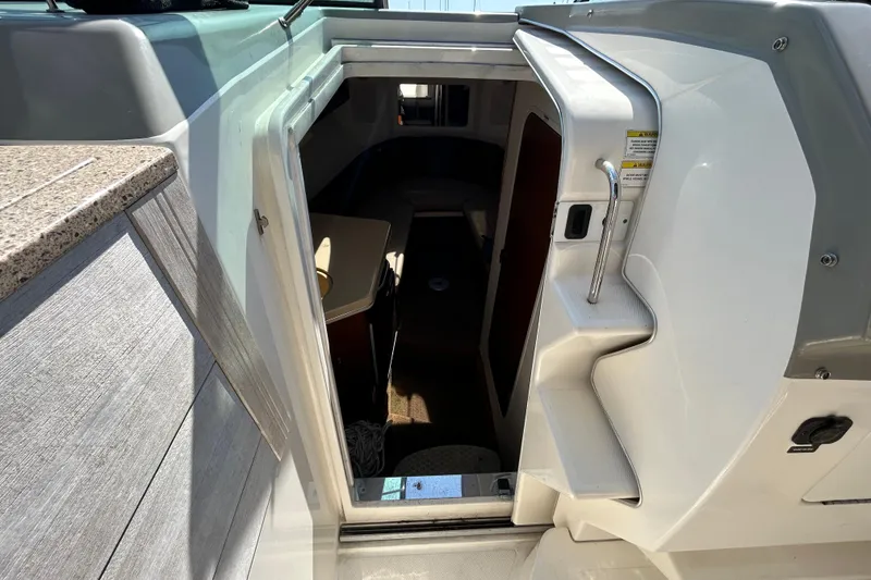 Slide: The Image of 2014 Sea Ray Sundancer 260 boat interior with seating and wooden table. - 76