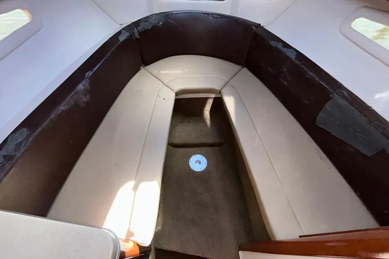 Slide: The Image of 2014 Sea Ray Sundancer 260 boat interior with cushioned seating and wooden table. - 78