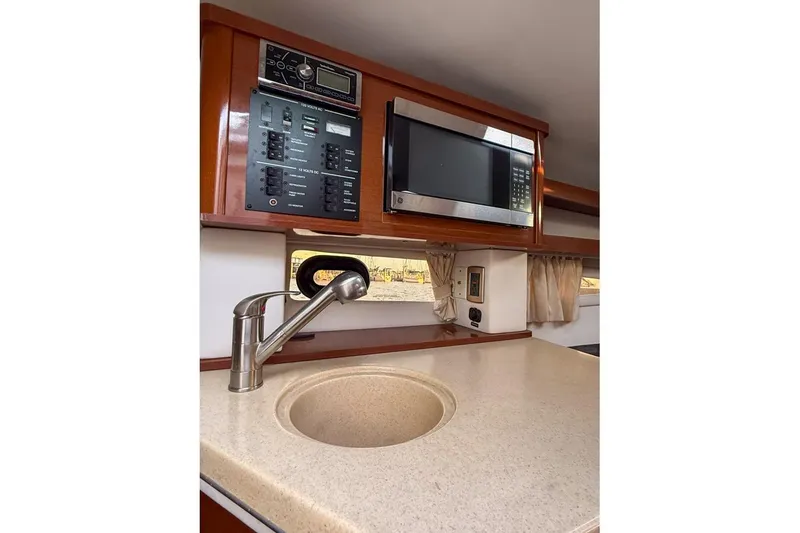 Slide: The Image of 2014 Sea Ray Sundancer 260 interior with sink, microwave, and control panel. - 9