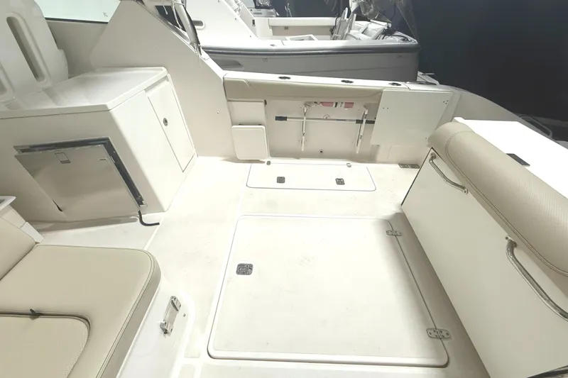 Slide: The Image of 2018 Pursuit DC 325 Dual Console boat interior with seating and storage compartments. - 11