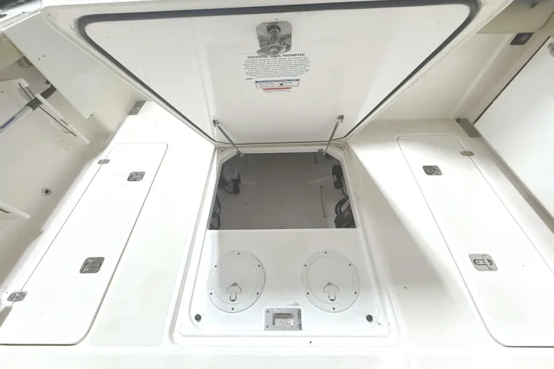 Slide: The Image of Open storage compartment on 2018 Pursuit DC 325 Dual Console boat. - 12