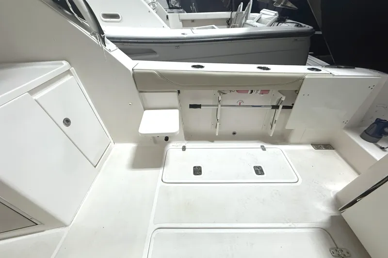 Slide: The Image of 2018 Pursuit DC 325 Dual Console boat interior with storage compartments and seating. - 13