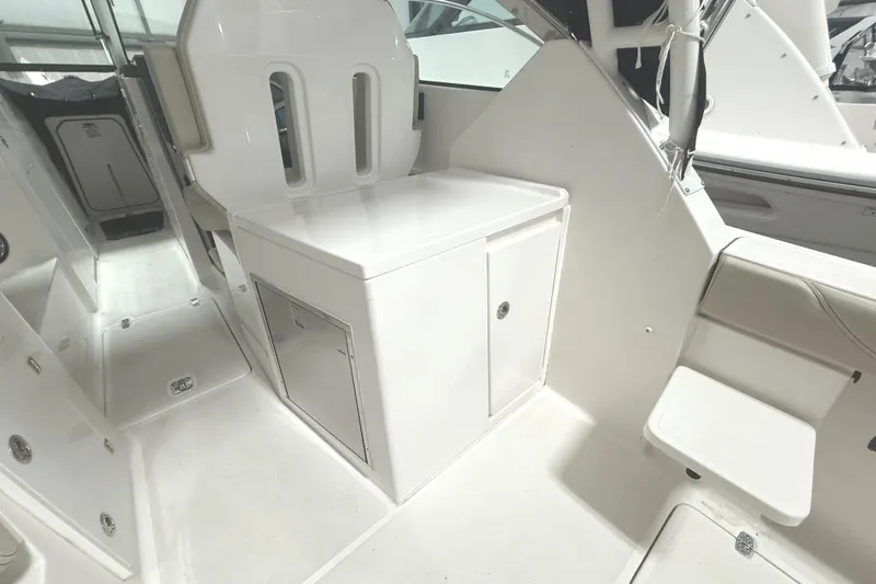 Slide: The Image of 2018 Pursuit DC 325 Dual Console interior with white seating and storage compartments. - 14