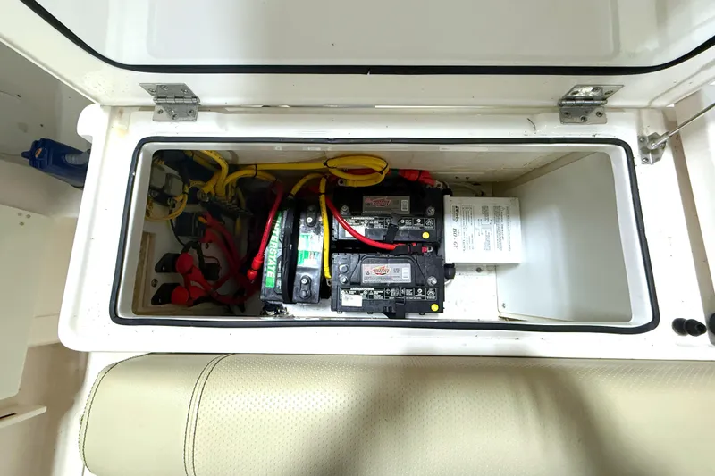 Slide: The Image of 2018 Pursuit DC 325 Dual Console battery compartment with wiring and components. - 16