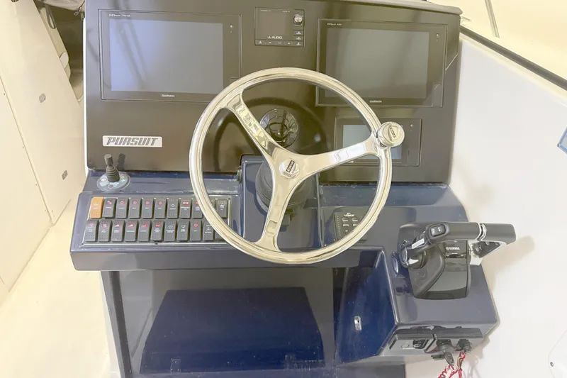 Slide: The Image of Control panel of 2018 Pursuit DC 325 Dual Console boat with steering wheel and navigation screens. - 24