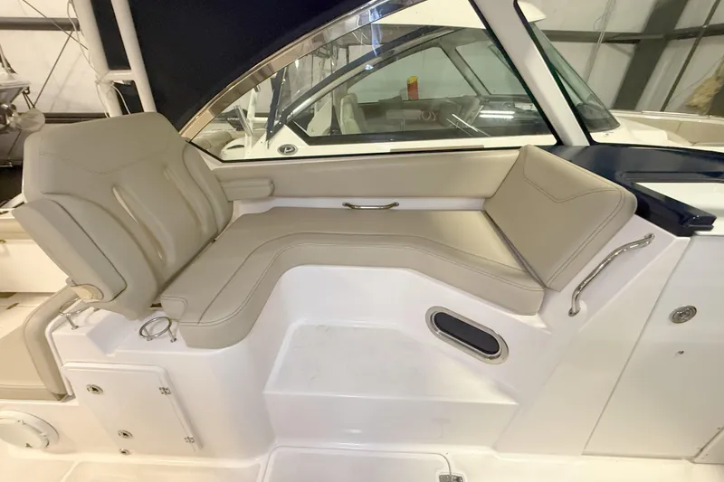 Slide: The Image of 2018 Pursuit DC 325 Dual Console interior seating with beige upholstery and sleek design. - 25