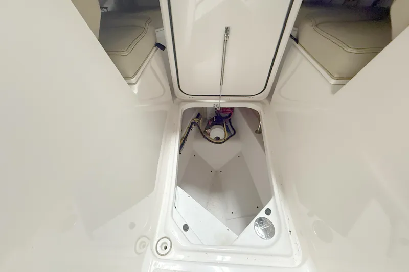 Slide: The Image of 2018 Pursuit DC 325 Dual Console storage compartment with open hatch and visible interior components. - 30