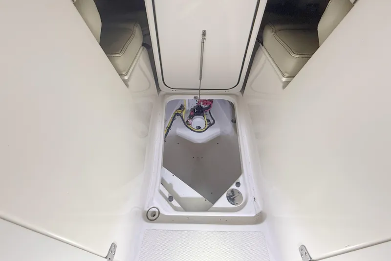 Slide: The Image of 2018 Pursuit DC 325 Dual Console storage compartment with open hatch and visible wiring. - 31