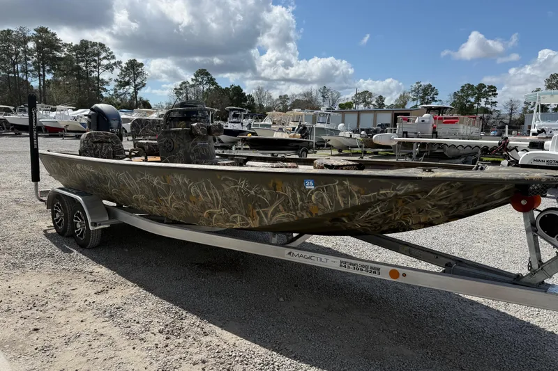 Slide: The Image of 2022 War Eagle 2170 Blackhawk boat on trailer, camo design, parked outdoors. - 13