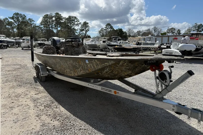 Slide: The Image of 2022 War Eagle 2170 Blackhawk boat on trailer in outdoor lot, surrounded by other boats. - 14