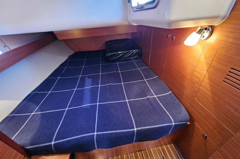 Slide: The Image of Cozy cabin interior of 2018 Dufour 460 Grand Large yacht with checkered bedding. - 19