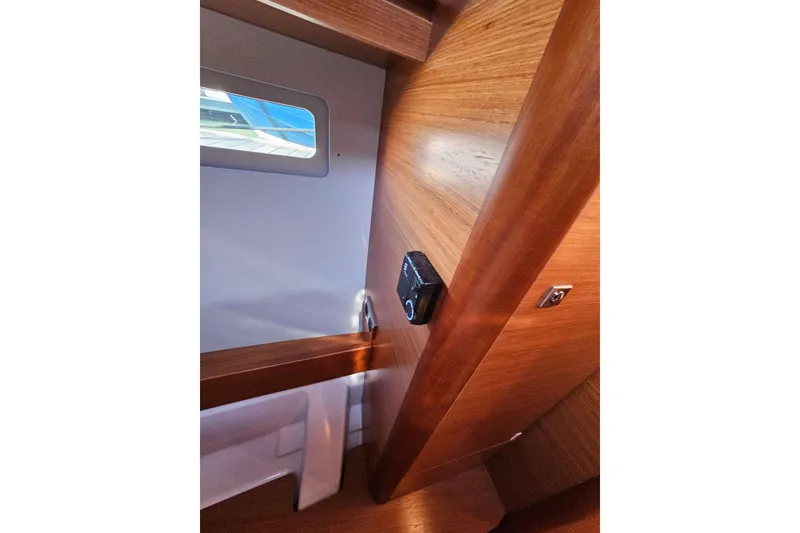 Slide: The Image of Interior view of 2018 Dufour 460 Grand Large yacht, featuring wooden paneling and a window. - 31