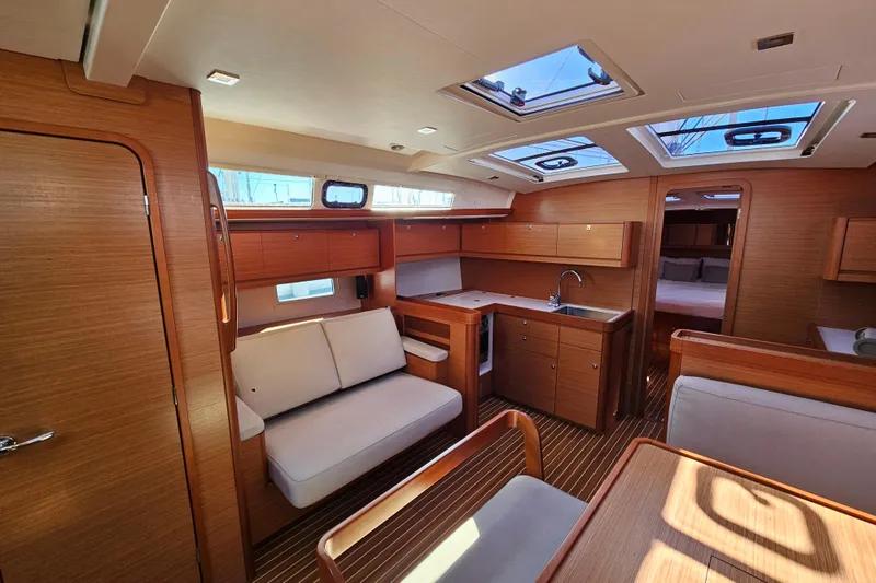 Slide: The Image of Interior of 2018 Dufour 460 Grand Large yacht, featuring modern wood finish and spacious layout. - 9