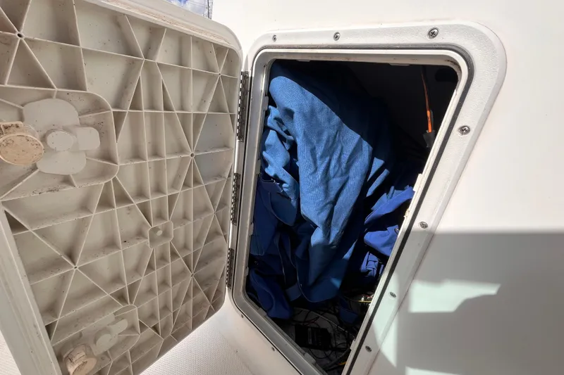 Slide: The Image of Open storage compartment on 2014 Tidewater 196 DC Explorer boat, containing blue fabric. - 15