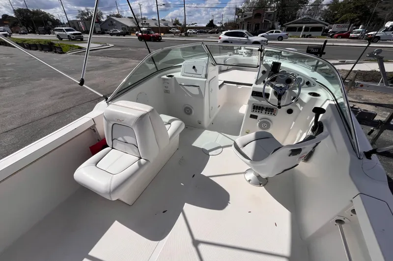 Slide: The Image of 2014 Tidewater 196 DC Explorer boat interior with white seating and steering console. - 7