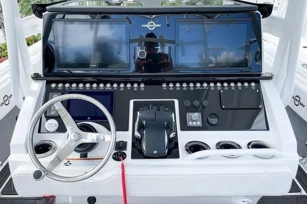 Slide: The Image of 2023 Fountain 34 Tournament Edition boat dashboard with steering wheel and control panel. - 10