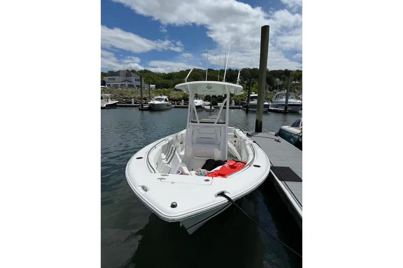 Slide: The Image of 2016 Sea Hunt Ultra 235 SE boat docked at marina under partly cloudy sky. - 2