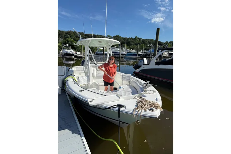 Slide: The Image of 2016 Sea Hunt Ultra 235 SE boat docked with person onboard, sunny day. - 3