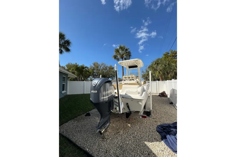 Slide: The Image of 2018 Key West 239 FS boat with Yamaha 250 engine, parked outdoors under clear blue sky. - 2