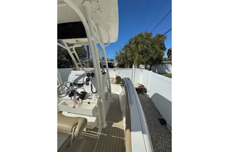 Slide: The Image of 2018 Key West 239 FS boat interior with steering console, parked outdoors. - 6