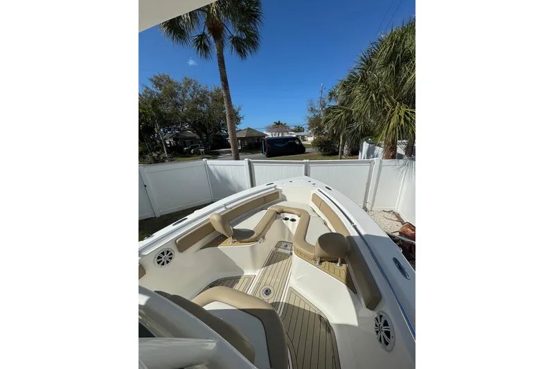 Slide: The Image of 2018 Key West 239 FS boat interior with seating, speakers, and palm trees in the background. - 8