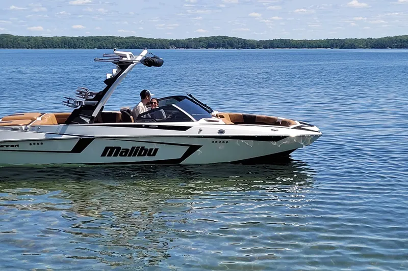 The Image of 2023 Malibu Wakesetter 23 MXZ boat on a clear lake under blue skies. - 0