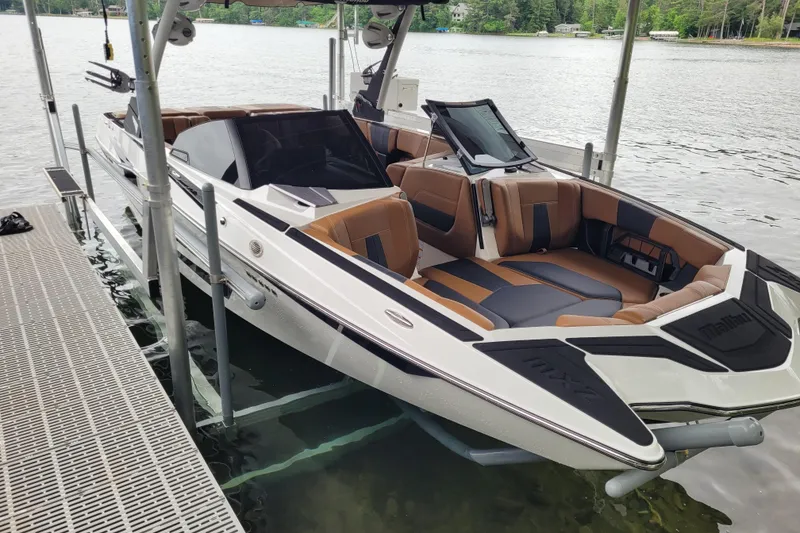 Slide: The Image of 2023 Malibu Wakesetter 23 MXZ boat docked on a serene lake. - 3