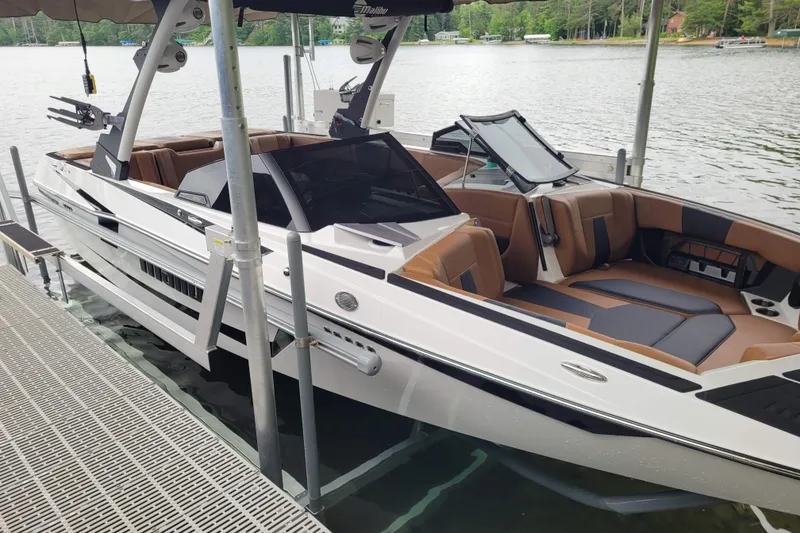 Slide: The Image of 2023 Malibu Wakesetter 23 MXZ boat docked on a lake with luxurious seating. - 4