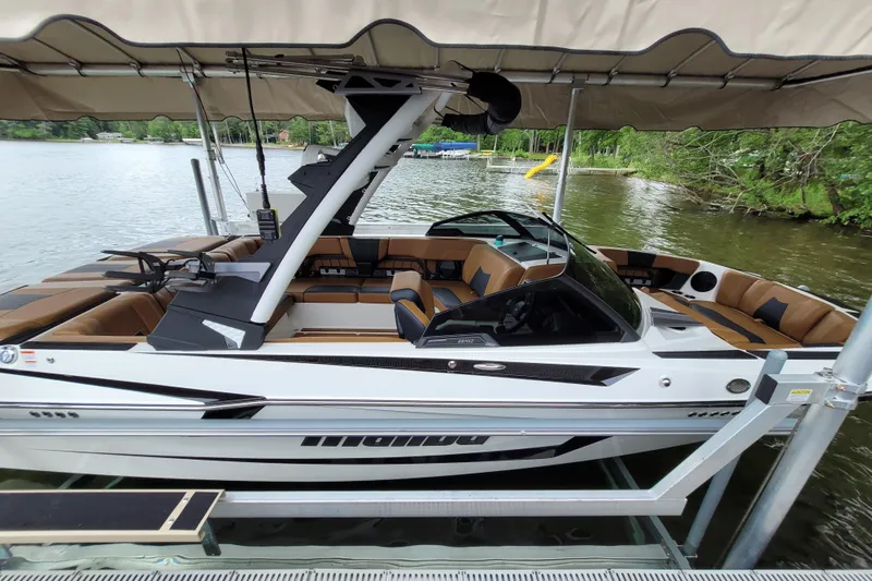 Slide: The Image of 2023 Malibu Wakesetter 23 MXZ boat docked on a serene lake. - 5