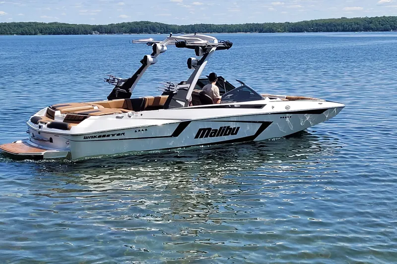 Slide: The Image of 2023 Malibu Wakesetter 23 MXZ boat on a serene lake. - 7