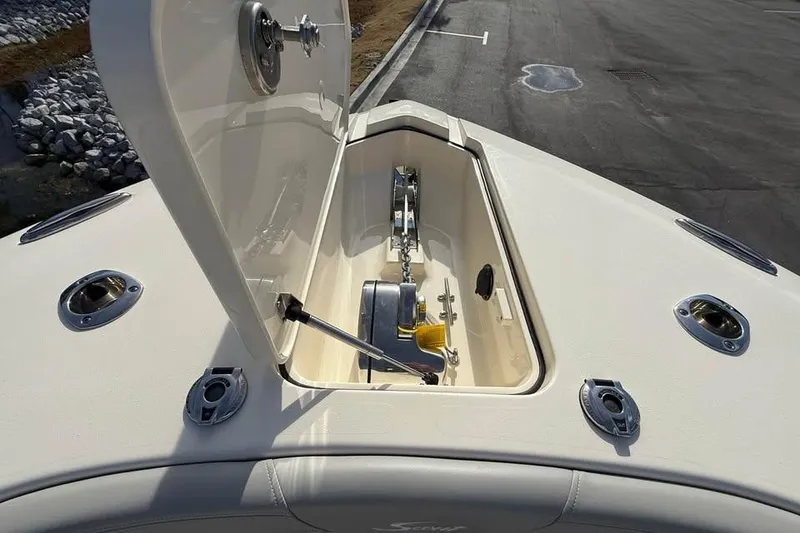 Slide: The Image of 2026 Scout 277 LXF boat anchor compartment with open hatch, showcasing storage and hardware. - 5