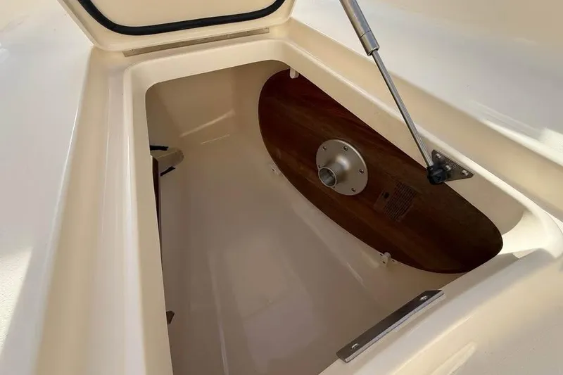 Slide: The Image of 2026 Scout 277 LXF boat storage compartment with hydraulic lift and wooden panel. - 6