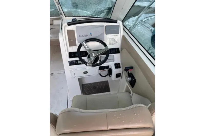 Slide: The Image of 2019 Sailfish 275 DC boat helm with Garmin navigation system and beige seating. - 2