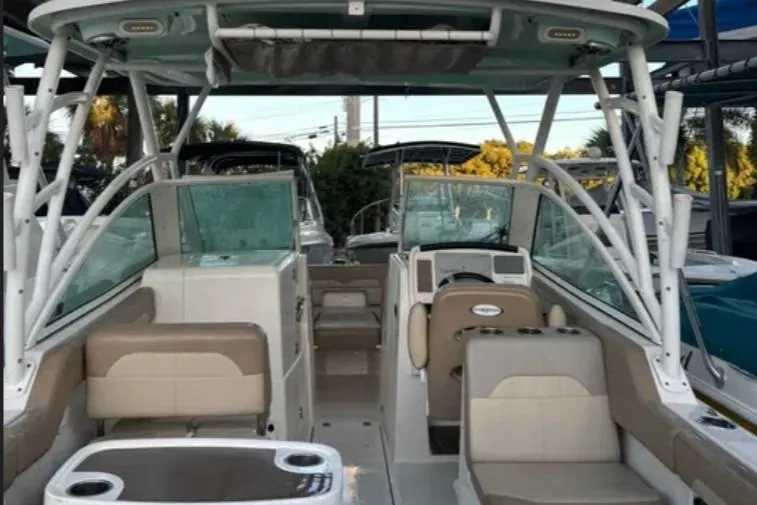 Slide: The Image of 2019 Sailfish 275 DC boat interior with seating and helm, docked outdoors. - 4