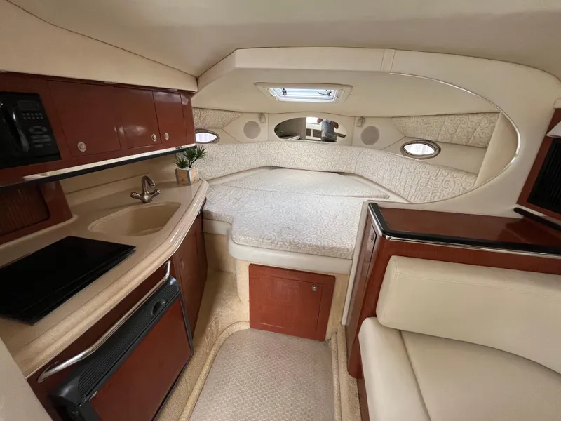 Slide: The Image of Interior cabin of 2005 Sea Ray 290 Amberjack with bed, kitchenette, and seating. - 12