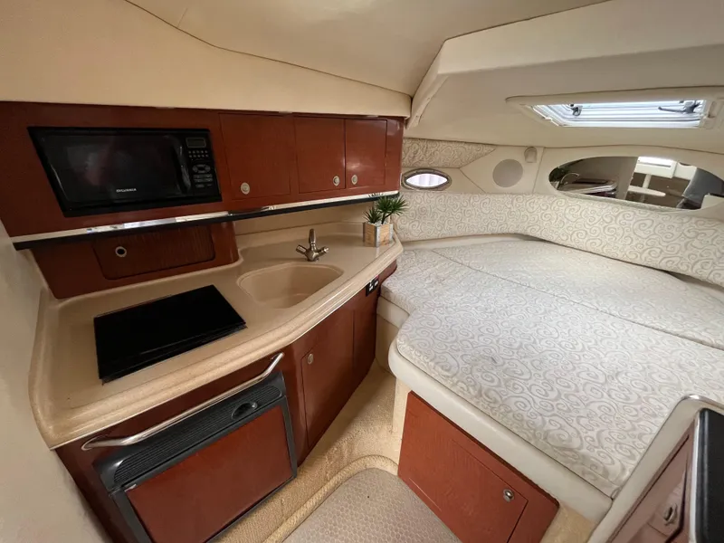 Slide: The Image of Interior of 2005 Sea Ray 290 Amberjack with kitchenette and cozy sleeping area. - 13
