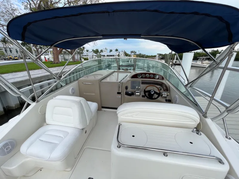 Slide: The Image of 2005 Sea Ray 290 Amberjack boat interior with white seating and blue canopy. - 6
