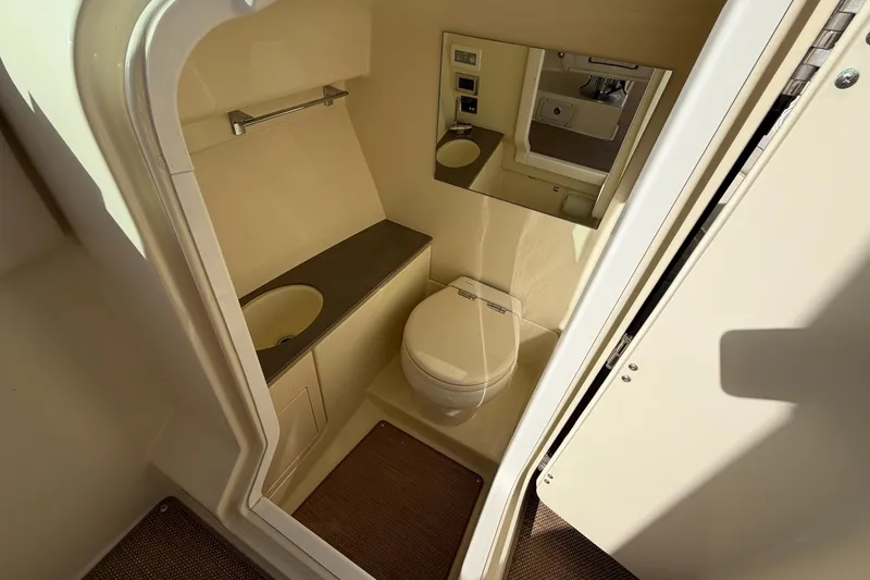 Slide: The Image of 2023 Chris-Craft Launch 28 GT boat bathroom interior with toilet, sink, and mirror. - 11