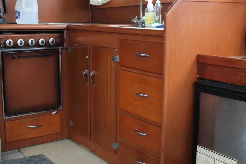 Slide: The Image of 1969 Pacemaker Tricabin kitchen with wooden cabinets, stove, and small fridge. - 26